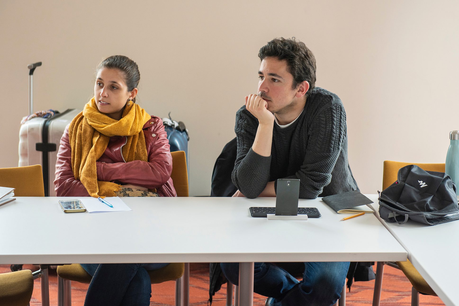 Two students participating in a workshop. Two students sitting at a table participating in a workshop.