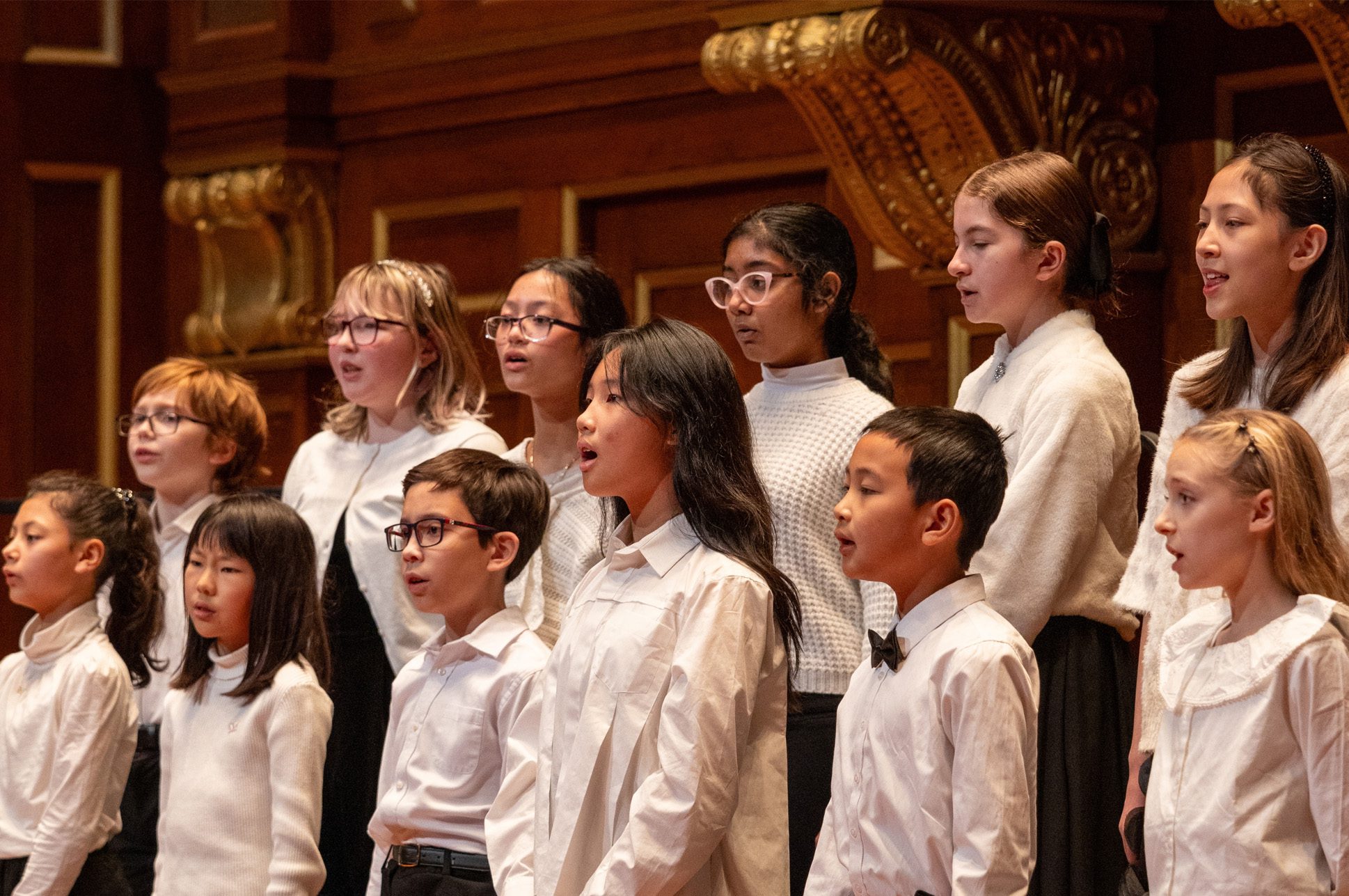 A group of young students signing in a choir.