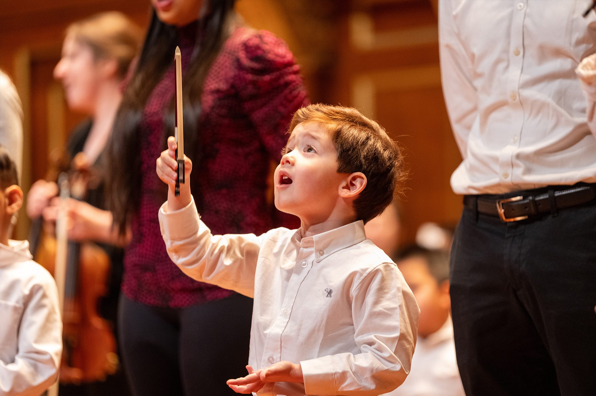 Young student holding a conductor's baton.