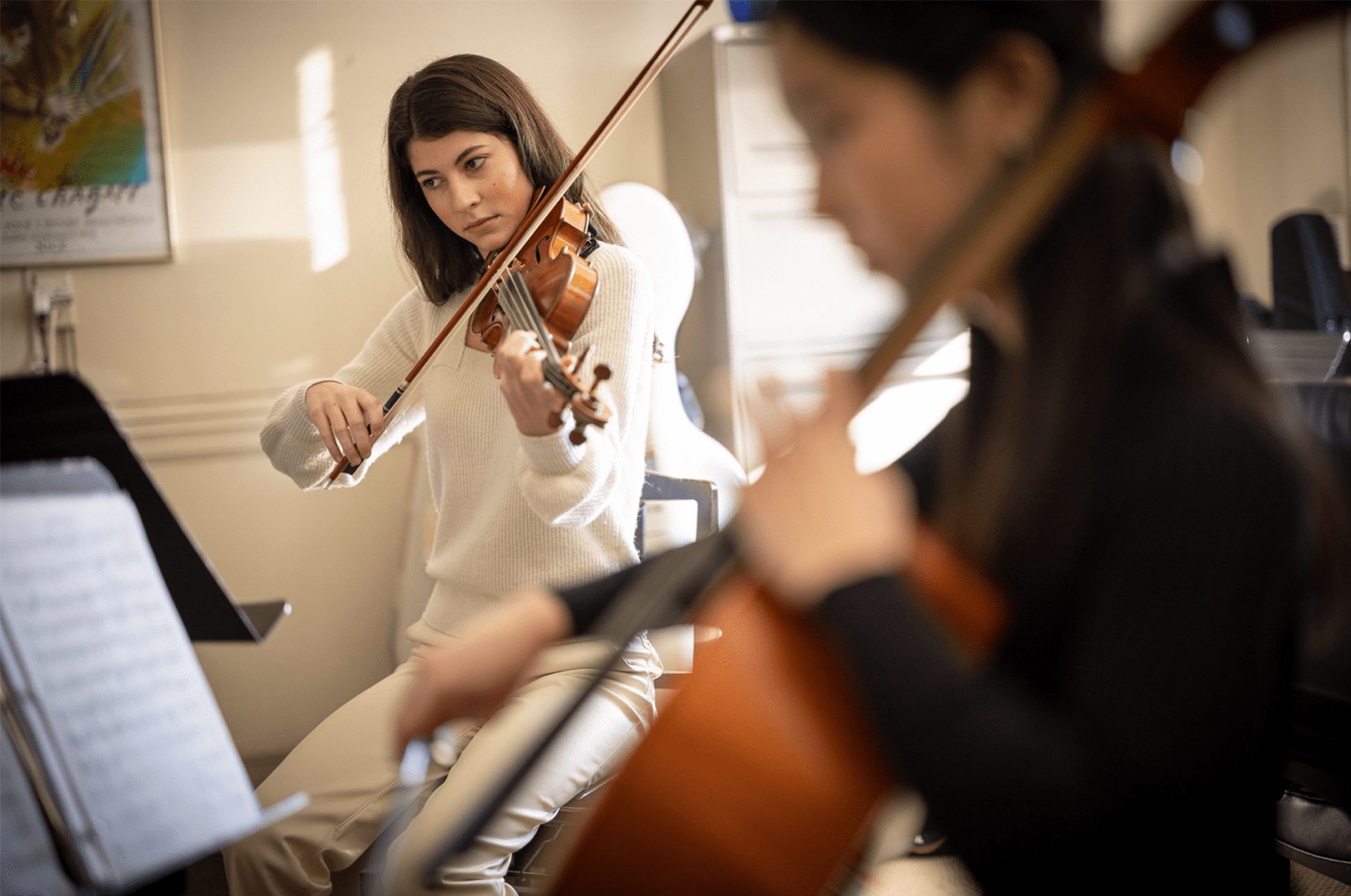 A violinist and cellist playing their instruments.