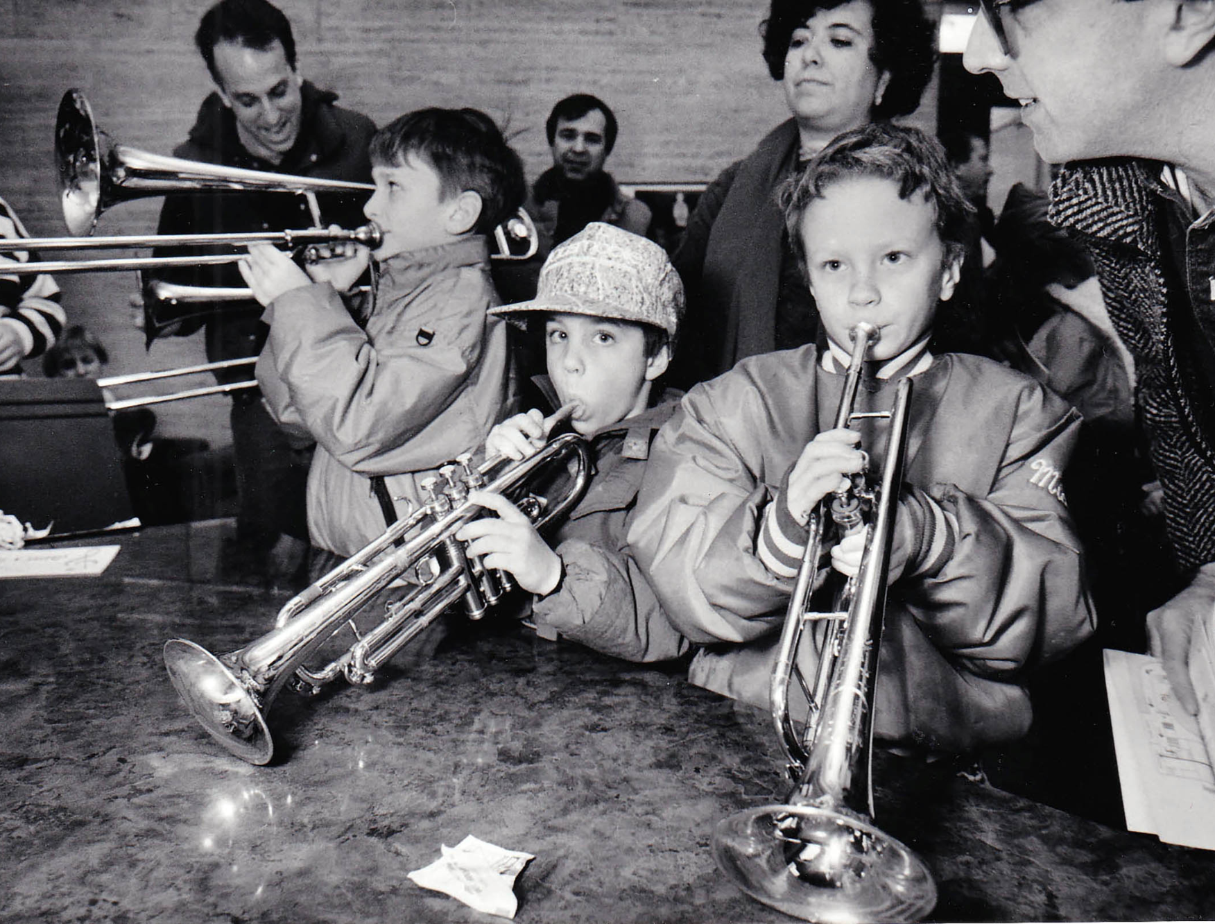 A group of kids trying out some brass instruments at the NEC Instrument Petting Zoo, an event held to introduce children to a variety of musical instruments, 1992. Photo by Jeff Thiebauth.