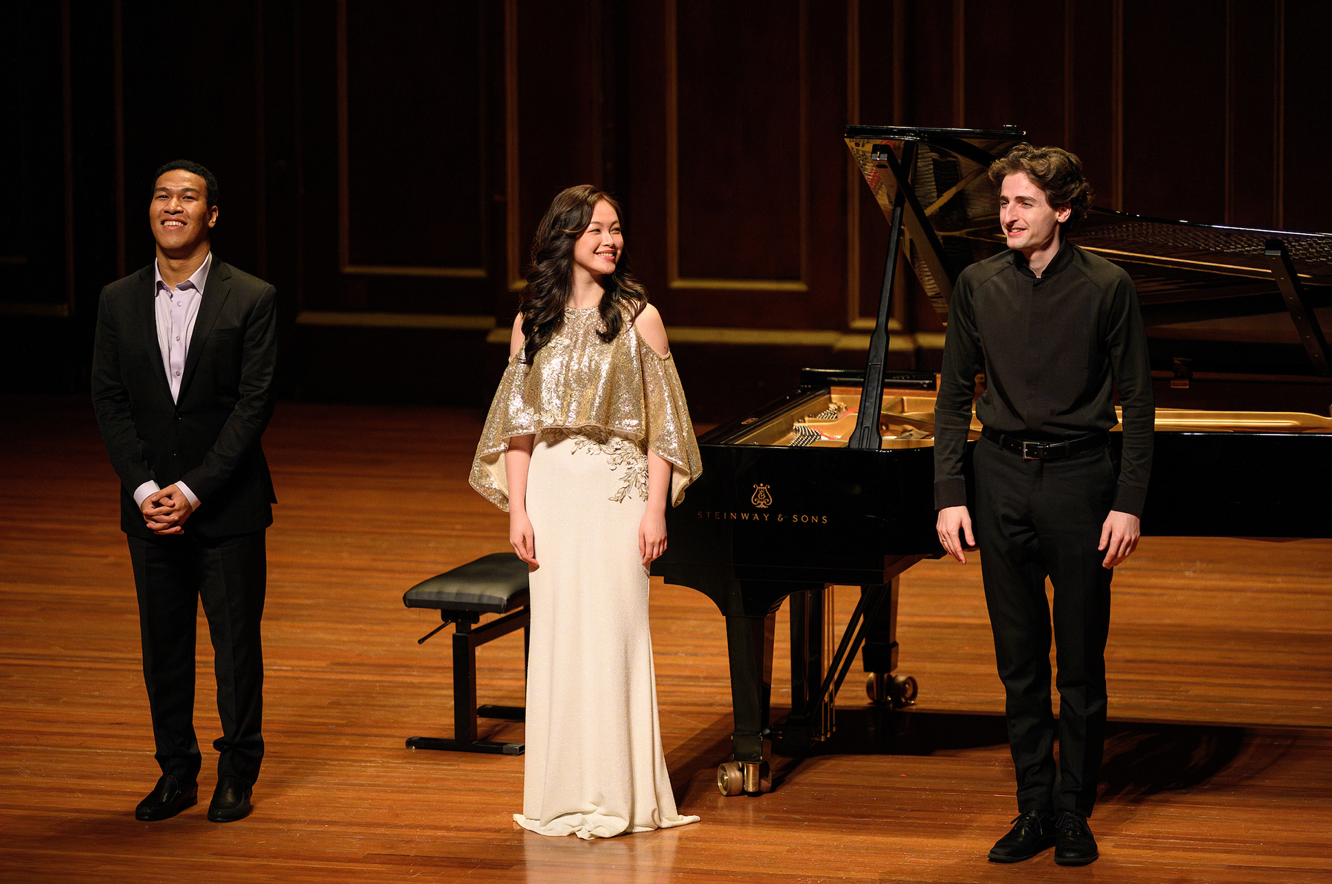 NEC Concert Artists Clayton Stephenson, Jingdan Dani Zhang, and Joshua Brown standing together on the Jordan Hall stage. NEC Concert Artists Clayton Stephenson, Jingdan Dani Zhang, and Joshua Brown standing together on the Jordan Hall stage.