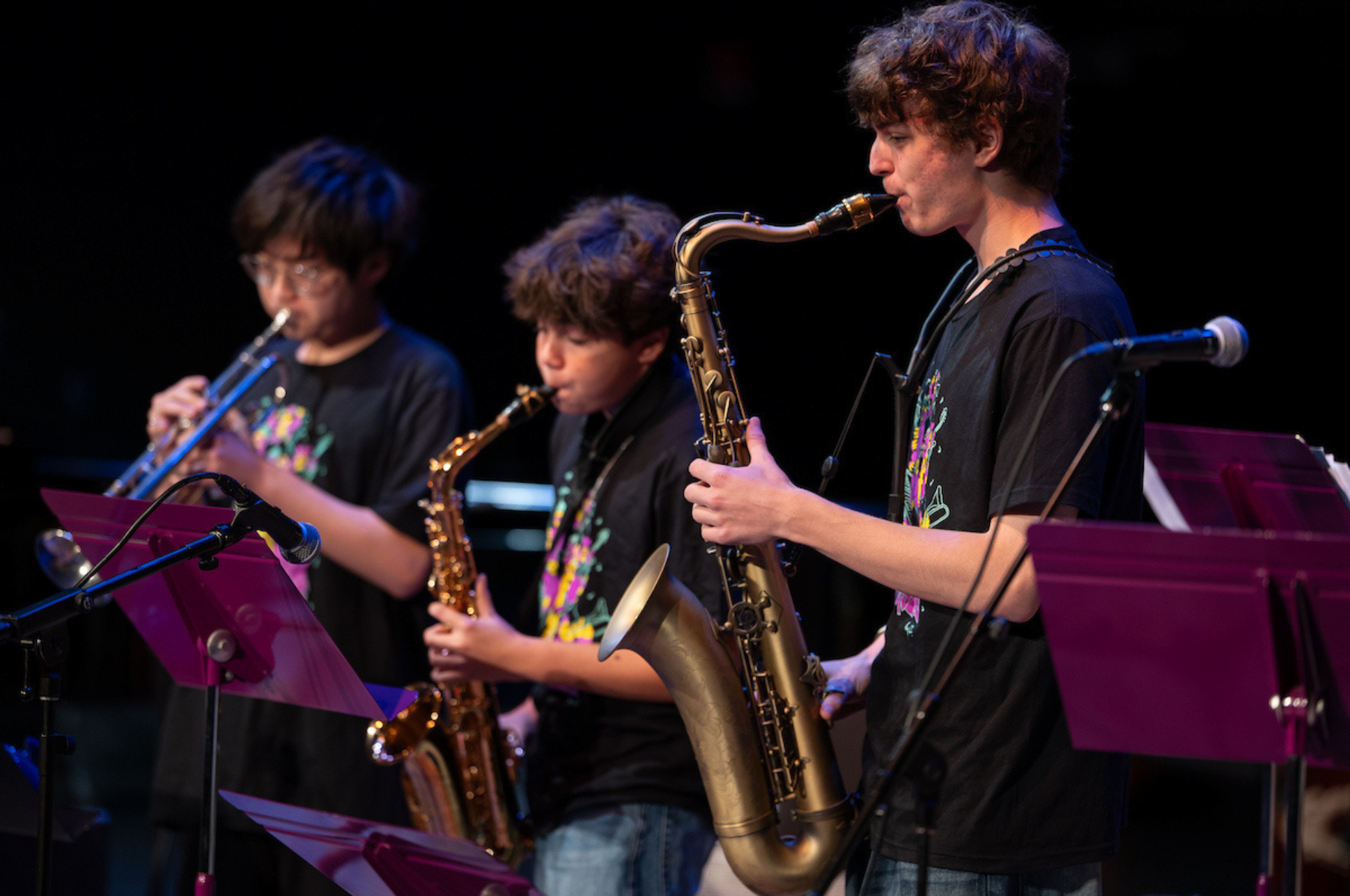 A group of teen playing the saxophone. 
